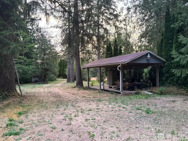 a backyard of a house with barbeque oven table and chairs