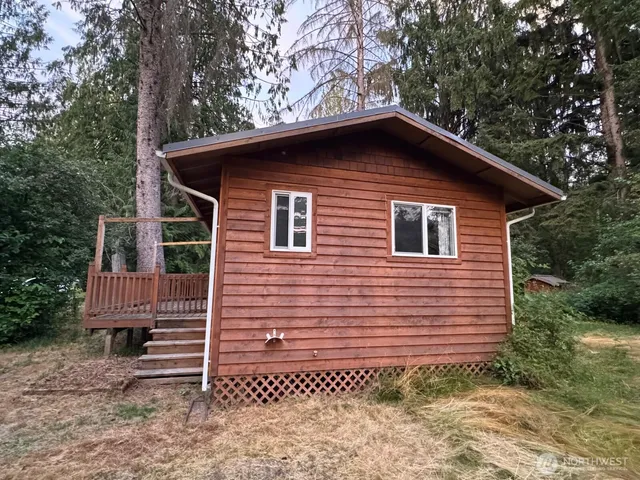 a brick house with a small yard and large trees