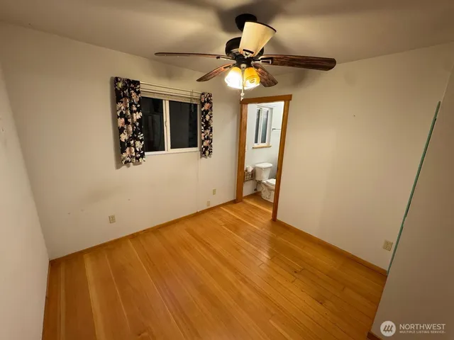 a view of empty room with wooden floor