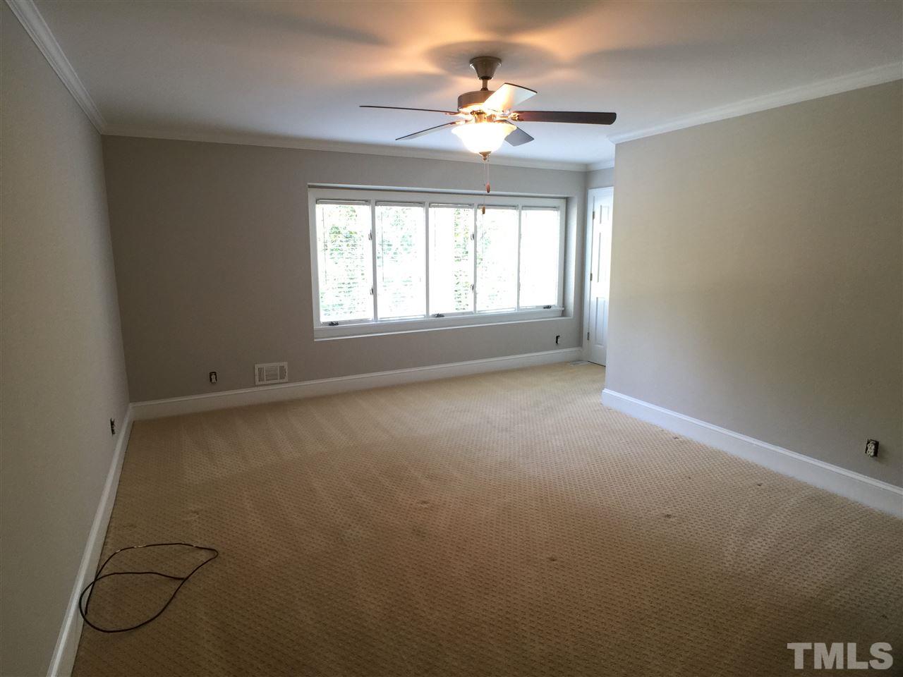 3105 Braddock Drive Raleigh, NC 27612 - Photo 12 of 19 en empty room with windows and chandelier fan