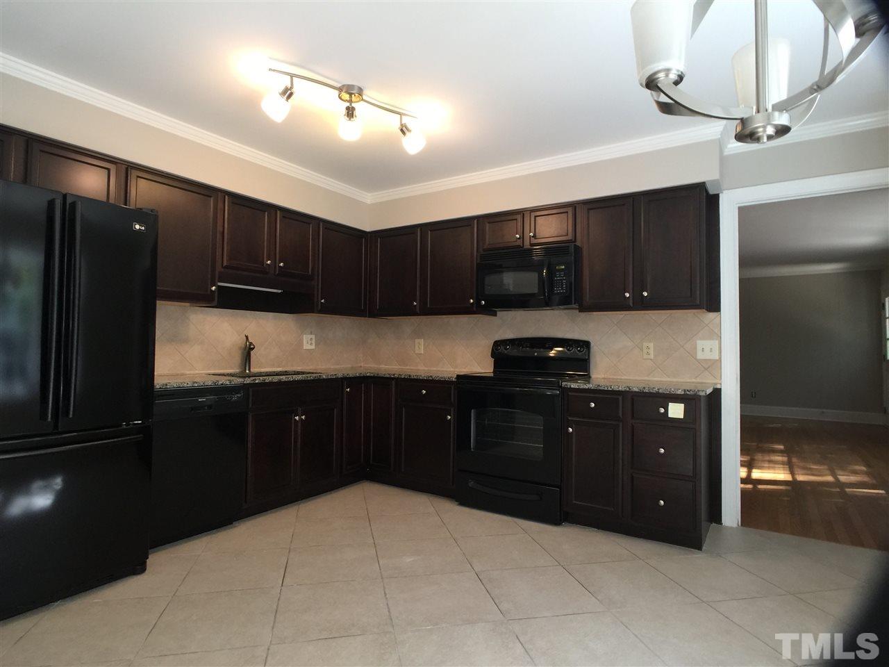 3105 Braddock Drive Raleigh, NC 27612 - Photo 10 of 19 a kitchen with stainless steel appliances granite countertop refrigerator a sink a stove a microwave and wooden cabinets