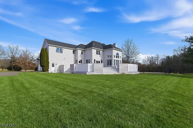 a view of a big house with a big yard and large trees