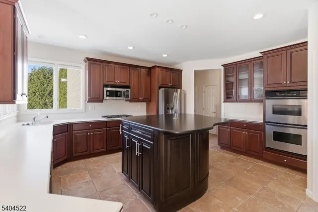 a kitchen with stainless steel appliances granite countertop a sink a stove and a refrigerator