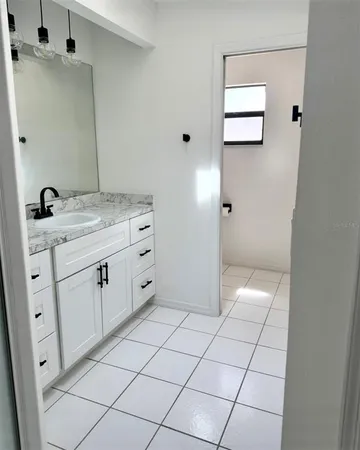 a bathroom with a granite countertop sink and a mirror