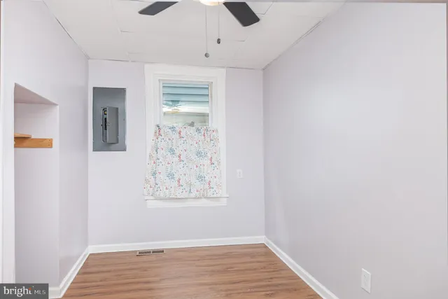a view of empty room with wooden floor
