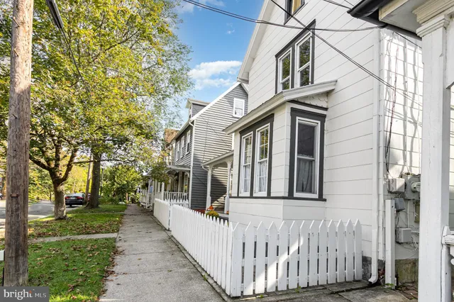 a view of a white house with iron fence