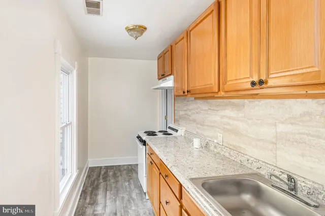 a bathroom with a granite countertop sink and a shower