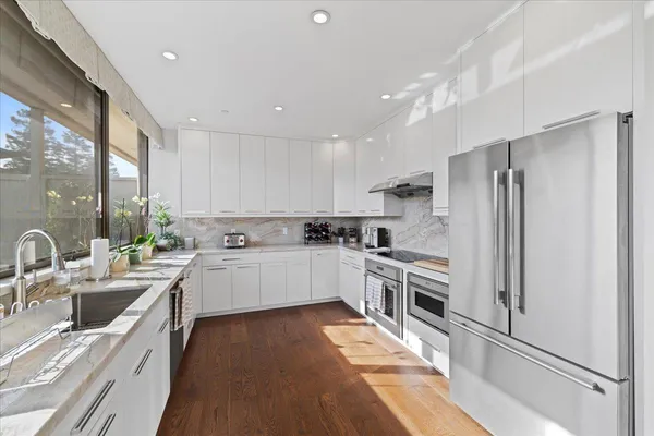 a kitchen with white cabinets and stainless steel appliances