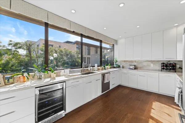a large white kitchen with a large window