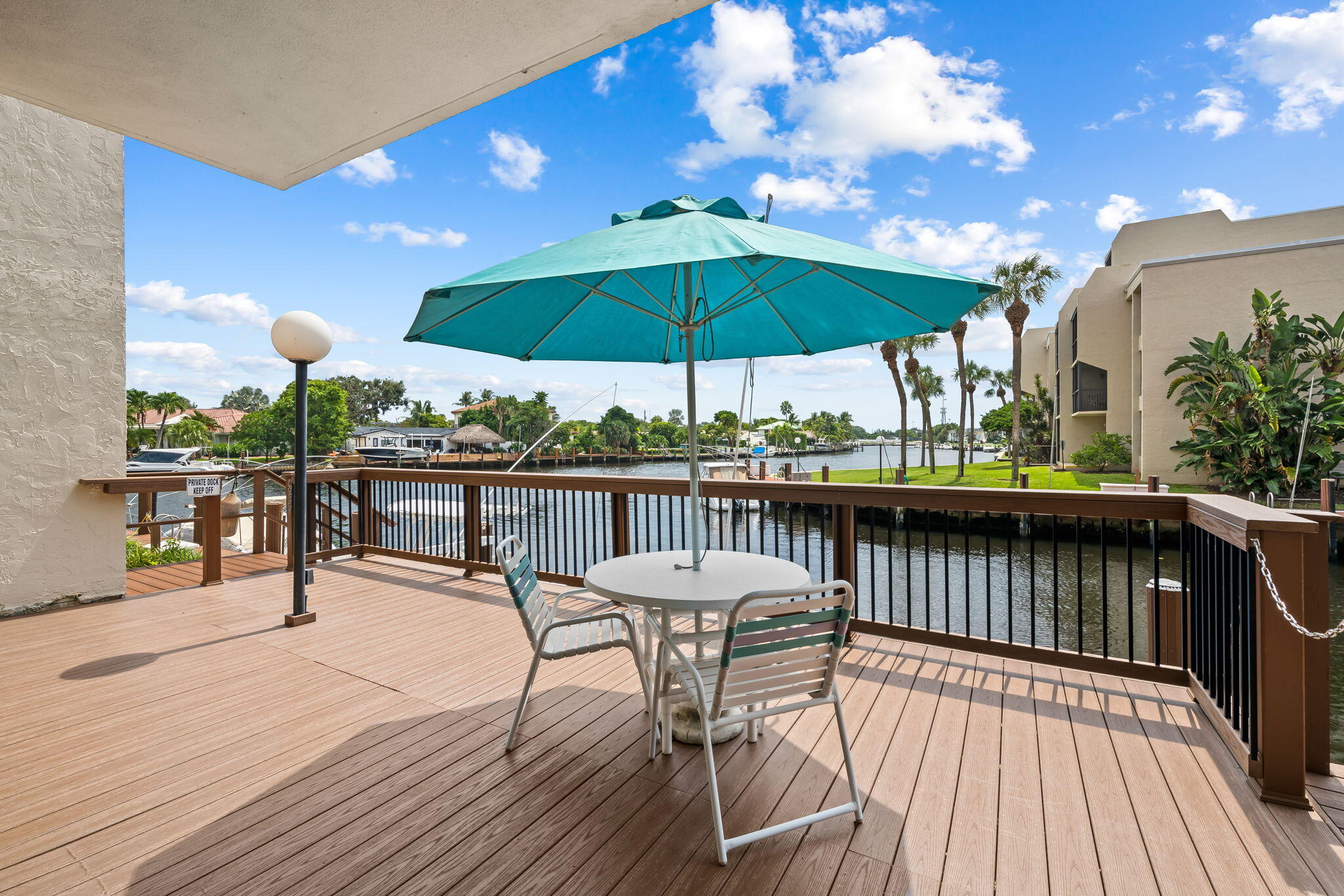 15 Royal Palm Way, Unit 505 Boca Raton, FL 33432 - Photo 20 of 32 a view of a roof deck with dining table and chairs under an umbrella with wooden floor