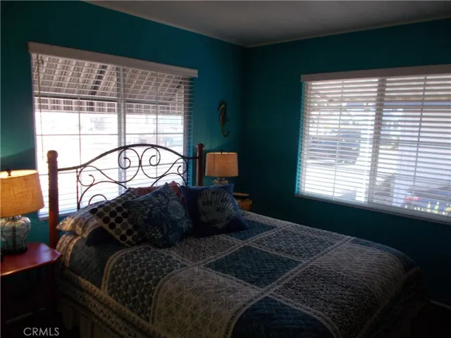 a bedroom with a bed next to a window with outer view