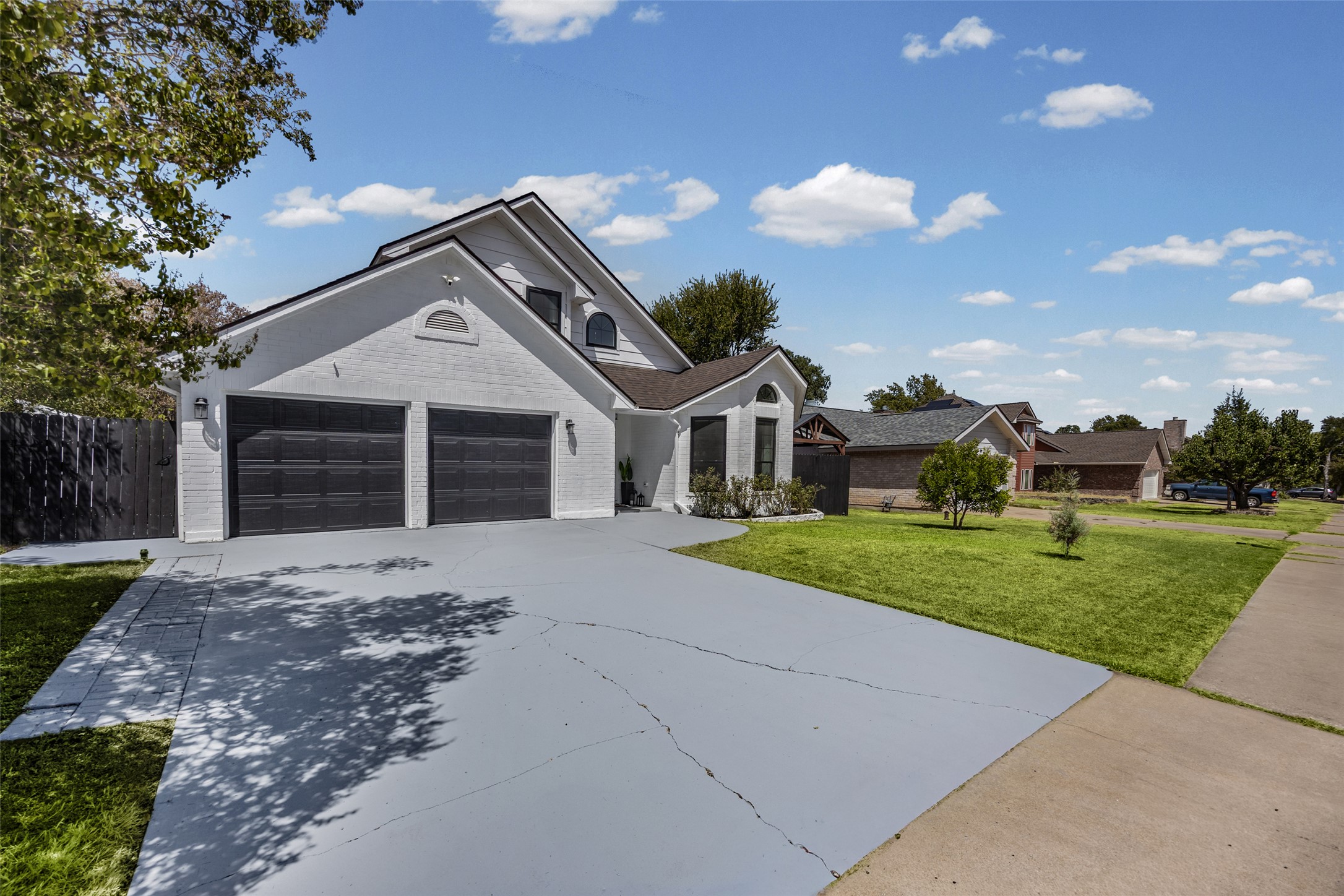 3006 Overland Street Round Rock, TX 78681 - Photo 2 of 29 An expansive concrete driveway leads to a modern exterior with a prominent two-car garage.