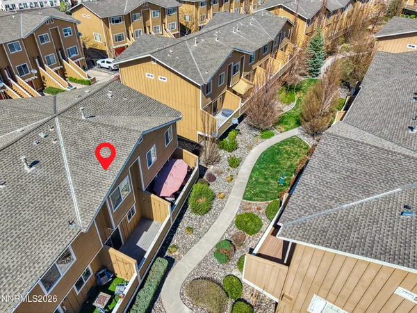 an aerial view of residential houses with outdoor space and ocean view