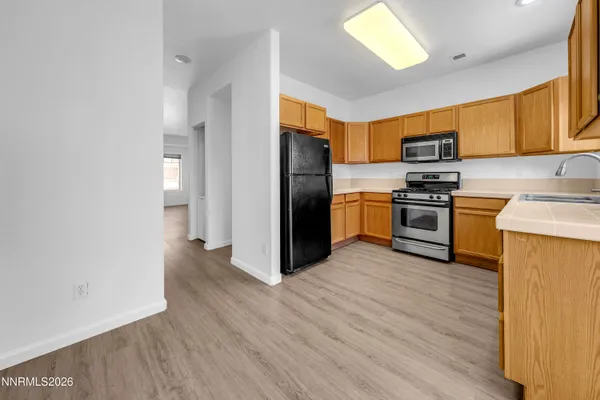 a kitchen with wooden floors and stainless steel appliances
