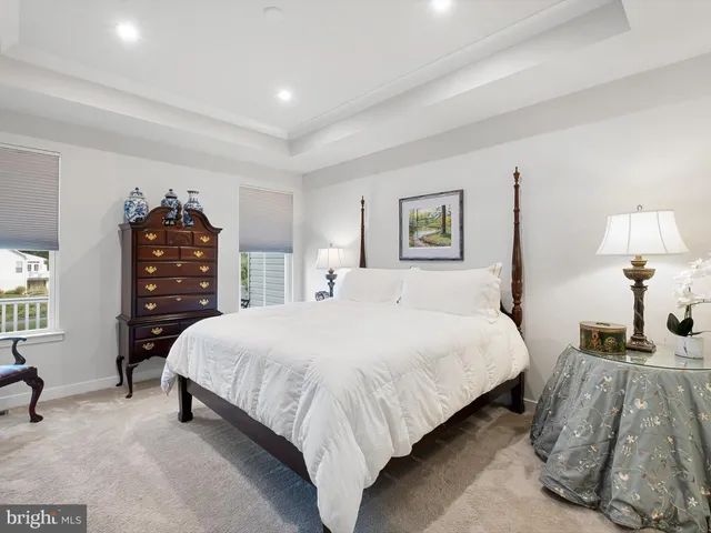 a bedroom with a bed and dresser with chair