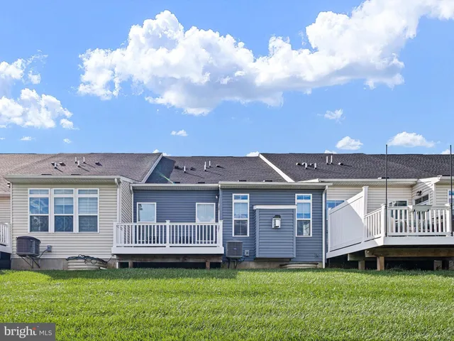 a view of a house with a big yard plants and large trees