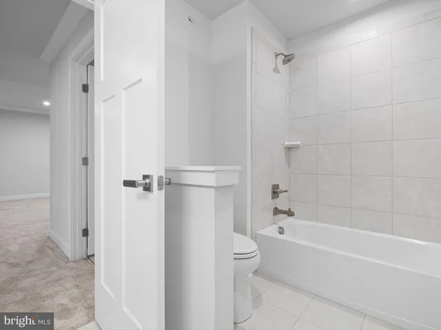 a bathroom with a bathtub shower and toilet