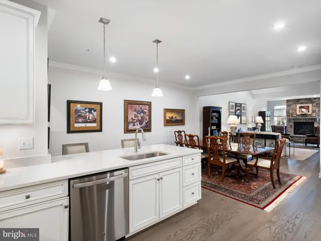 a living room with furniture a table and kitchen view