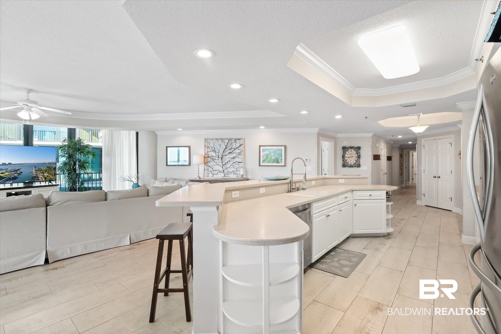 27582 Canal Road, Unit 2611 Orange Beach, AL 36561 - Photo 5 of 37 Kitchen featuring white cabinets, ceiling fan, a kitchen bar, and a spacious island