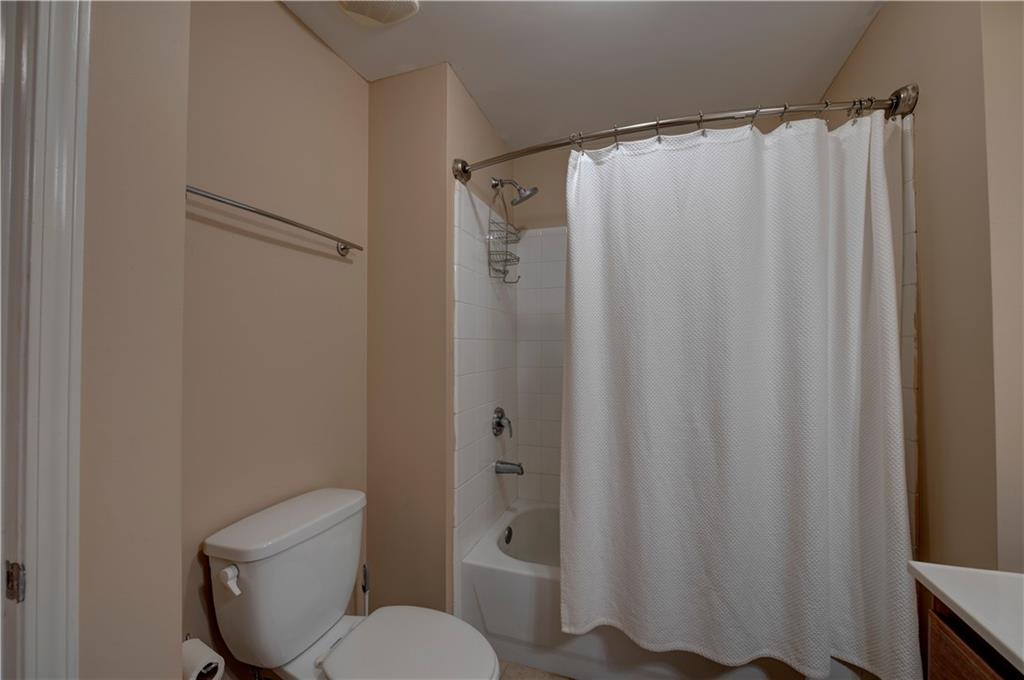3040 Peachtree Road, Unit 813 Atlanta, GA 30305 - Photo 14 of 28 a white toilet sitting next to a shower curtain