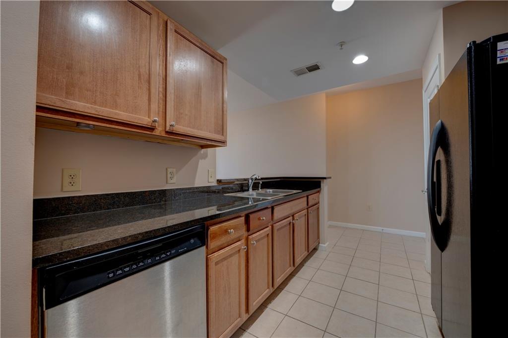 3040 Peachtree Road, Unit 813 Atlanta, GA 30305 - Photo 3 of 28 a kitchen with granite countertop a stove and a refrigerator