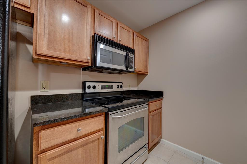3040 Peachtree Road, Unit 813 Atlanta, GA 30305 - Photo 6 of 28 a kitchen with granite countertop cabinets stainless steel appliances and wooden floor