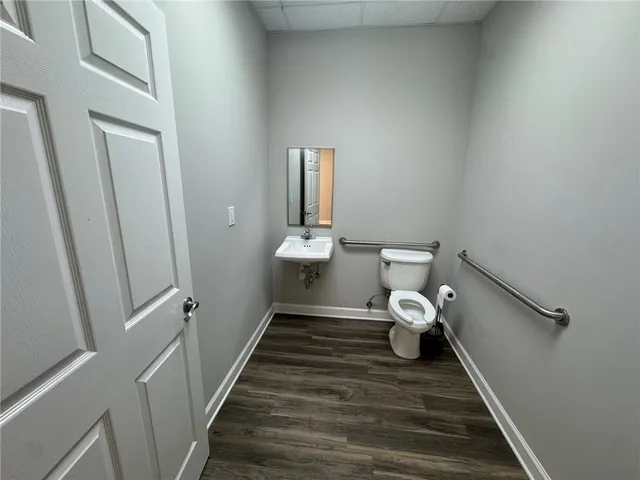 a bathroom with a toilet sink and mirror