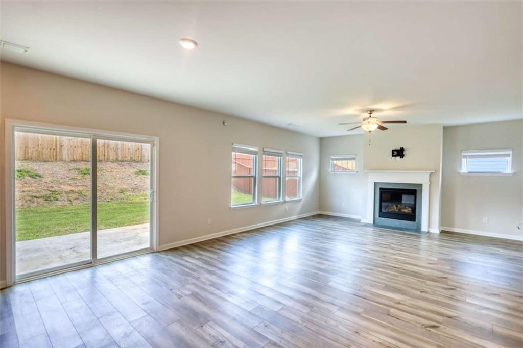 719 Sara Meadow Road Loganville, GA 30052 - Photo 12 of 74 a view of an empty room with wooden floor fireplace and a window