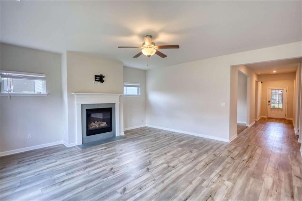 719 Sara Meadow Road Loganville, GA 30052 - Photo 13 of 74 a view of an empty room with wooden floor fireplace and a window