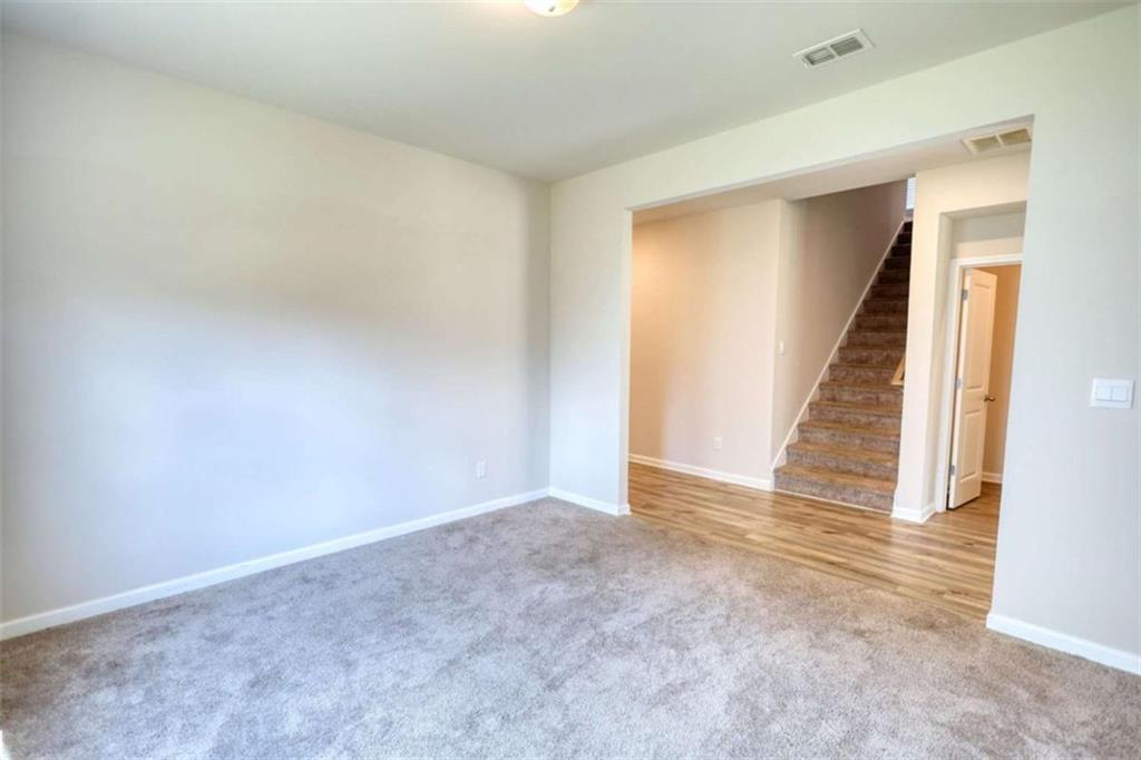 719 Sara Meadow Road Loganville, GA 30052 - Photo 18 of 74 a view of an empty room with wooden floor and entryway