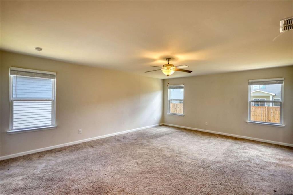 719 Sara Meadow Road Loganville, GA 30052 - Photo 35 of 74 en empty room with windows and chandelier fan