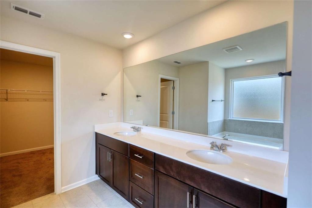 719 Sara Meadow Road Loganville, GA 30052 - Photo 40 of 74 a bathroom with a double vanity sink and a mirror