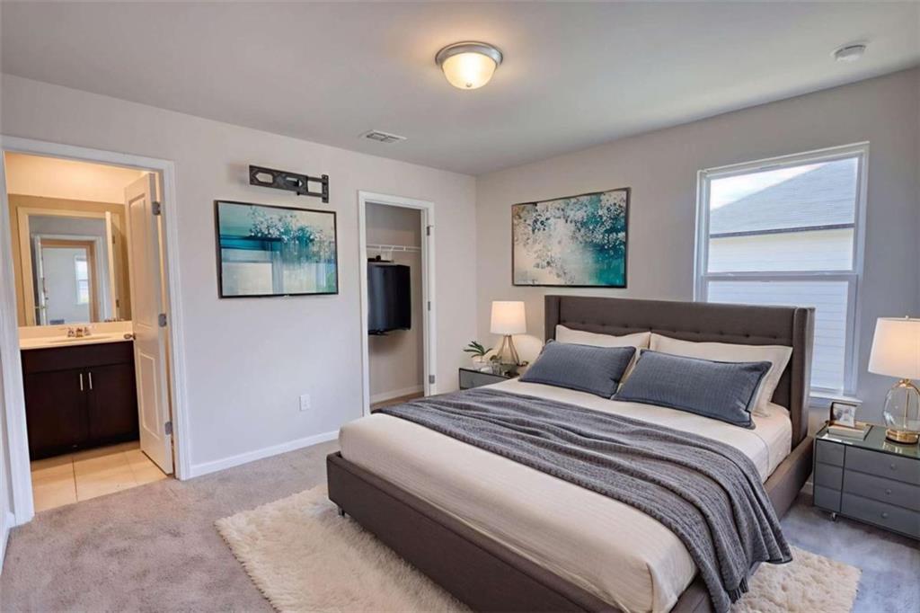 719 Sara Meadow Road Loganville, GA 30052 - Photo 48 of 74 a bedroom with a bed and a chandelier