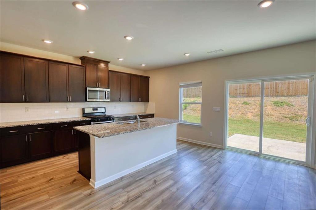 719 Sara Meadow Road Loganville, GA 30052 - Photo 7 of 74 a kitchen with stainless steel appliances granite countertop a stove a sink and a refrigerator