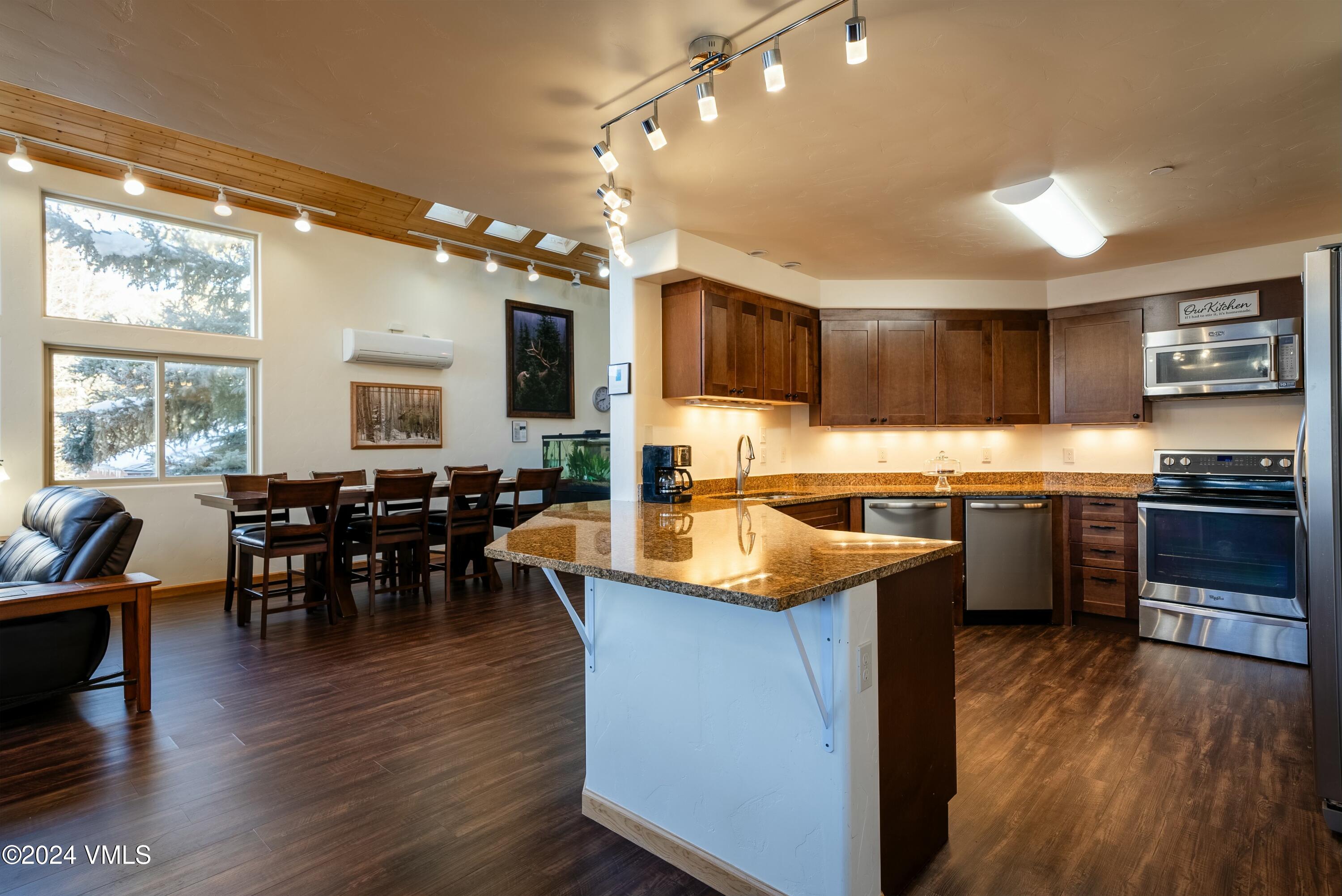 228-238 West Beaver Creek Boulevard, Unit A & B Avon, CO 81620 - Photo 16 of 72 a kitchen with kitchen island granite countertop wooden floors and a view of living room