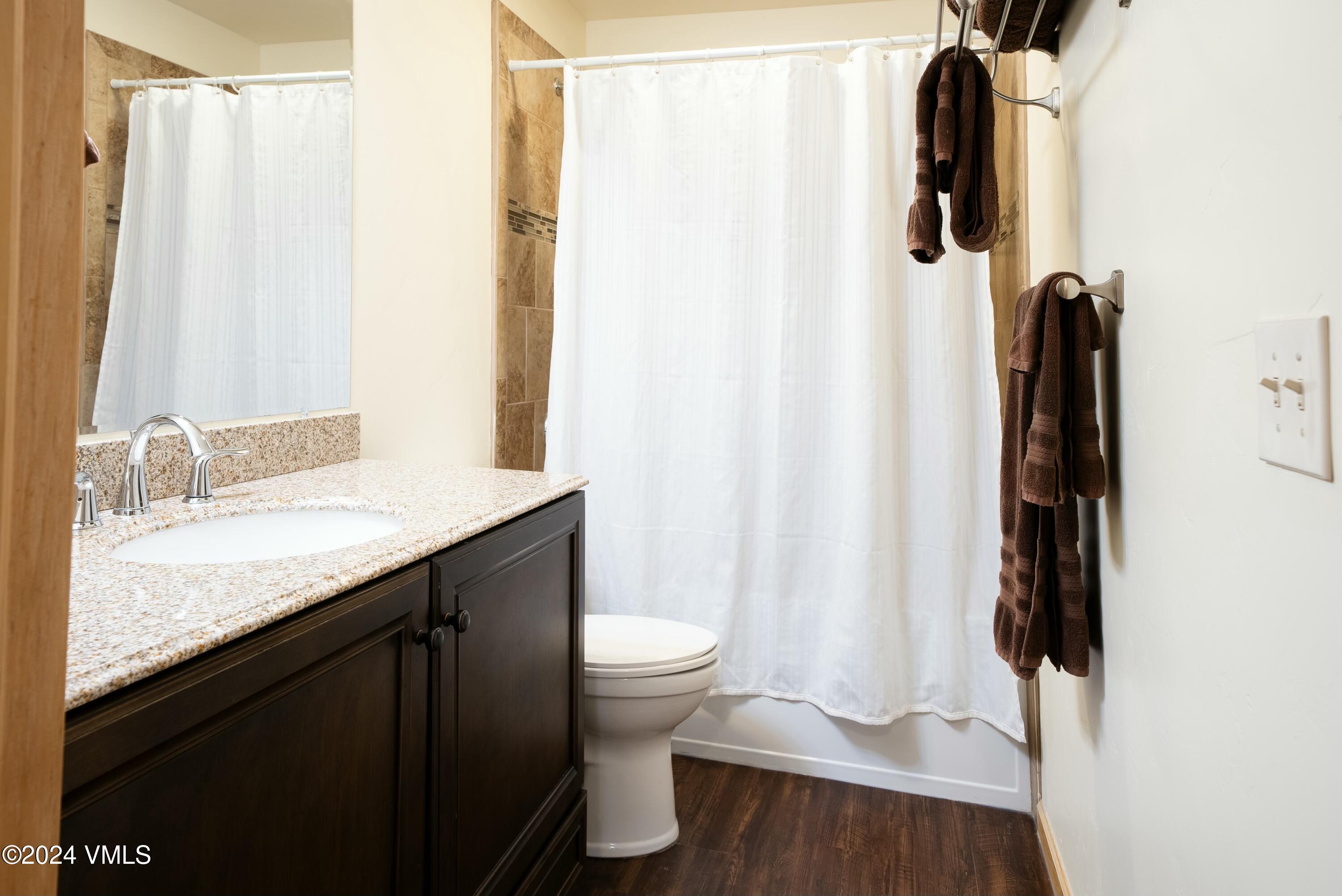 228-238 West Beaver Creek Boulevard, Unit A & B Avon, CO 81620 - Photo 22 of 72 a bathroom with a granite countertop sink toilet and a mirror