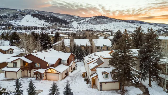 a bedroom with a bed a mirror on the dresser and a large window