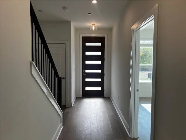 a view of a hallway with wooden floor and stairs