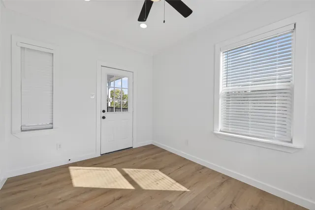 a view of an empty room with window and closet area