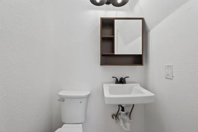 a bathroom with a toilet sink and mirror