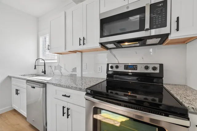 a kitchen with stainless steel appliances granite countertop a stove and a microwave
