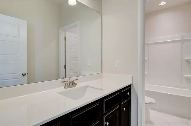 a bathroom with a sink a shower and a mirror