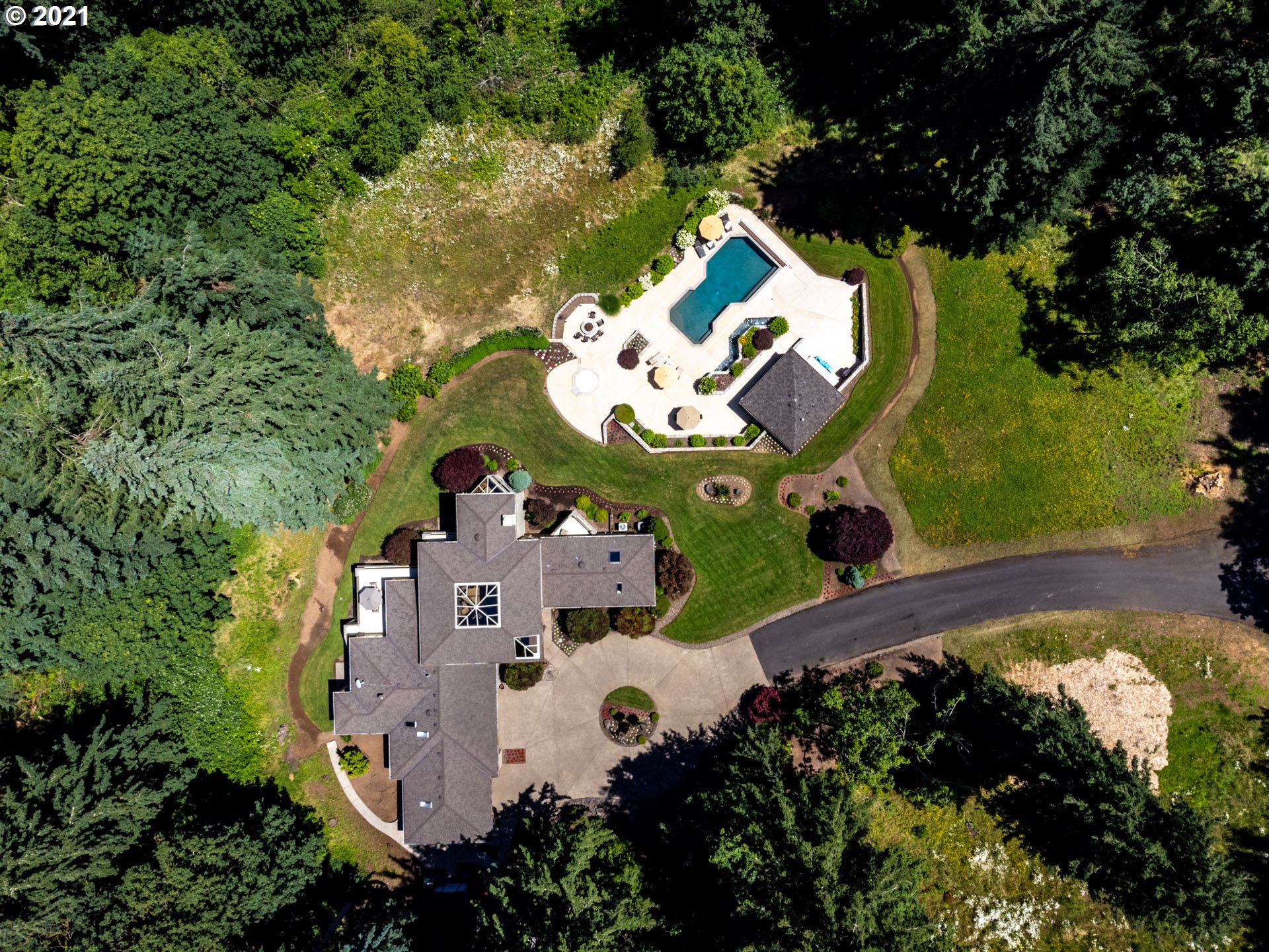 an aerial view of residential house with yard and swimming pool