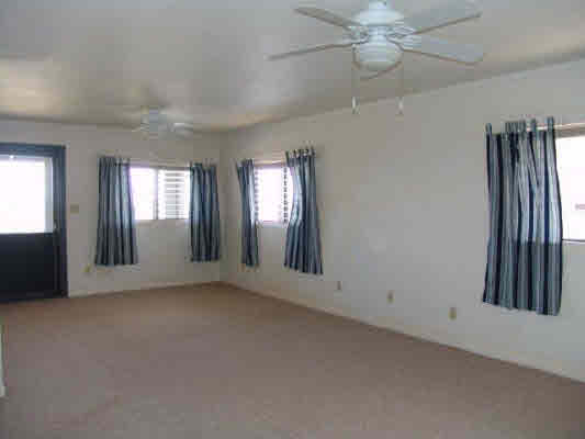 8393 Elepaio Road Kekaha, HI 96752 - Photo 8 of 10 an empty room with windows and fan