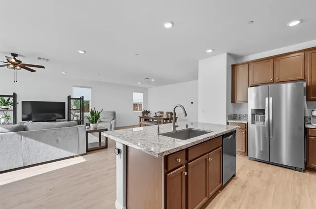 a kitchen with stainless steel appliances granite countertop a sink stove and refrigerator