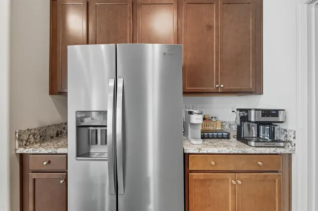 a kitchen with stainless steel appliances granite countertop a refrigerator and a stove