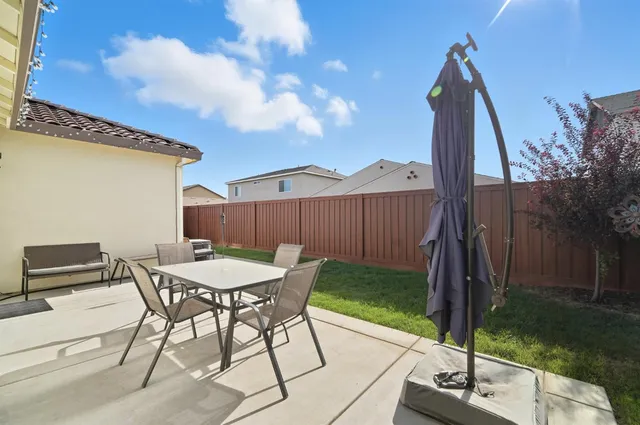 a view of a house with patio and a yard