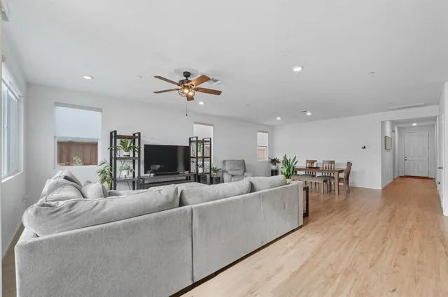 a living room with furniture and a wooden floor