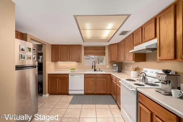 a kitchen with a sink a refrigerator and cabinets