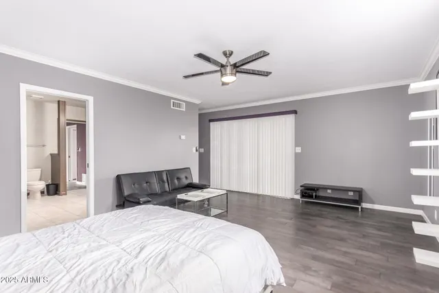 a bedroom with a bed and wooden floor